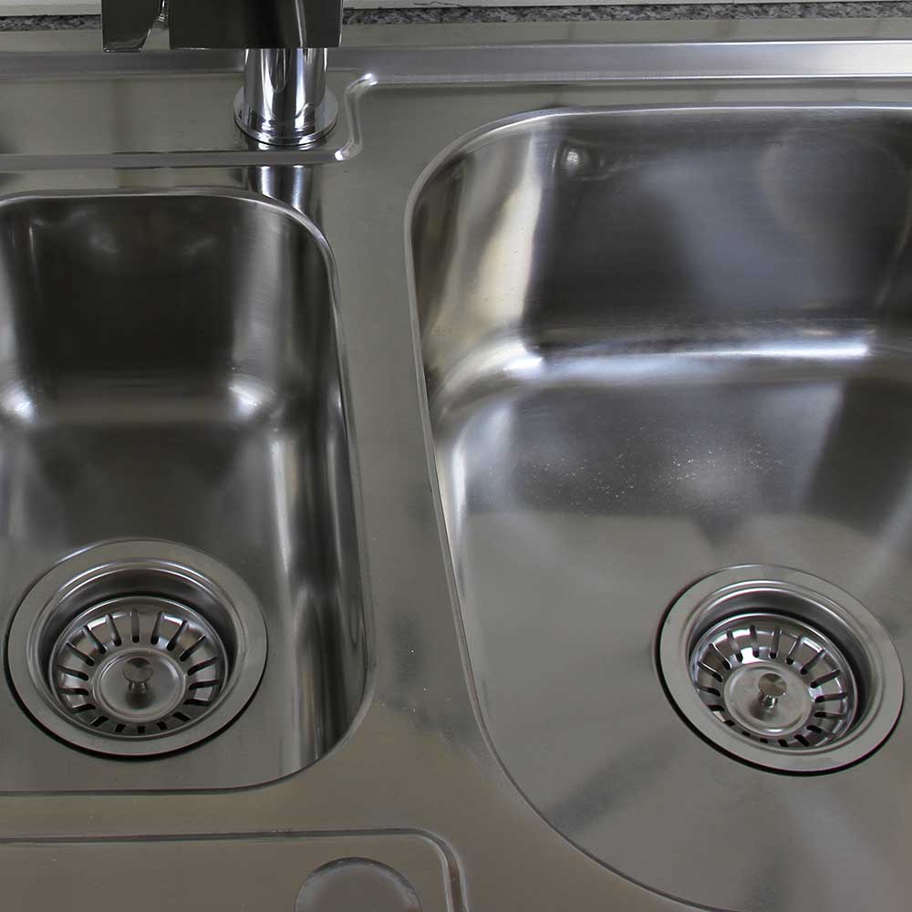 Premium RVS keukenspoelbak met twee diepe compartimenten, glanzend oppervlak en ronde afvoeren voor efficiënt waterbeheer