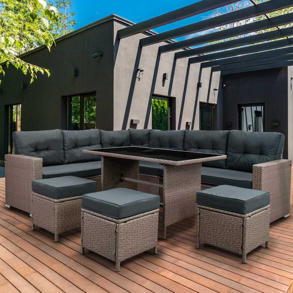 Polyrattan hoekmeubelset in grijs met comfortabele kussens, perfect voor buitengebruik op een houten terras met moderne architectuur