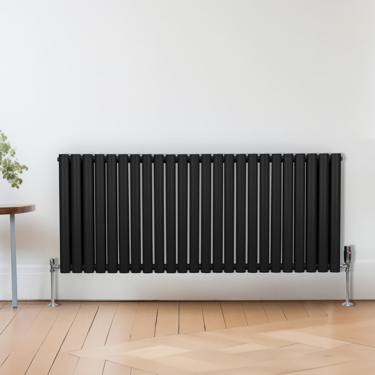Zwart metalen radiatorkraan met een chroomafwerking, strak design en verticale lamellen, geplaatst tegen een lichte muur