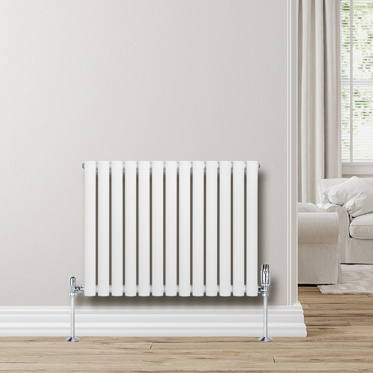Ovale witte design radiator met één kolom, 600 mm x 780 mm, inclusief haakse thermostaatkraan, geplaatst tegen een lichte muur