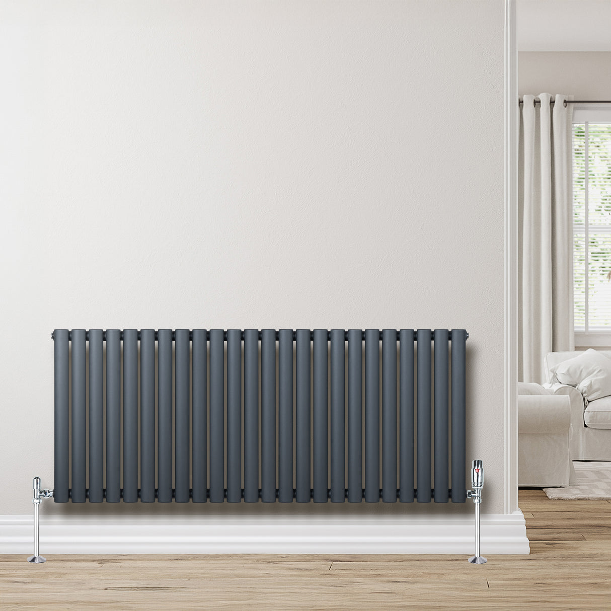 Ovale design radiator in antraciet grijs met een kolom, 600 mm x 1440 mm, inclusief haakse thermostaatkraan, tegen een lichte muur