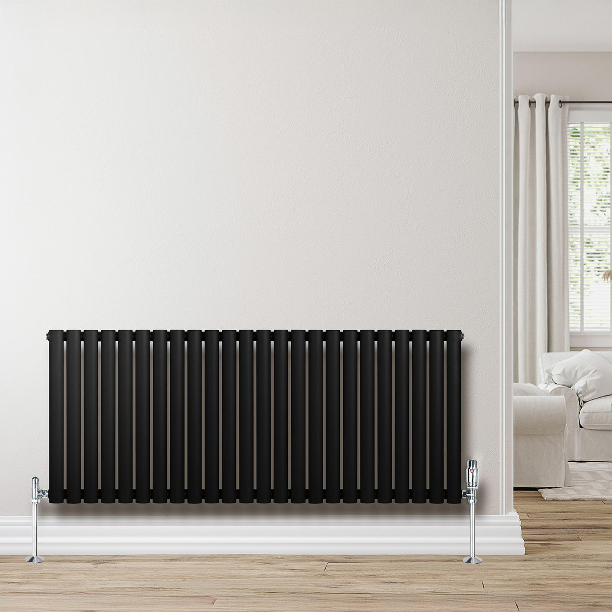 Ovale zwarte designradiator met één kolom, 600 mm x 1440 mm, inclusief haakse thermostaatkraan, geplaatst tegen een lichte muur
