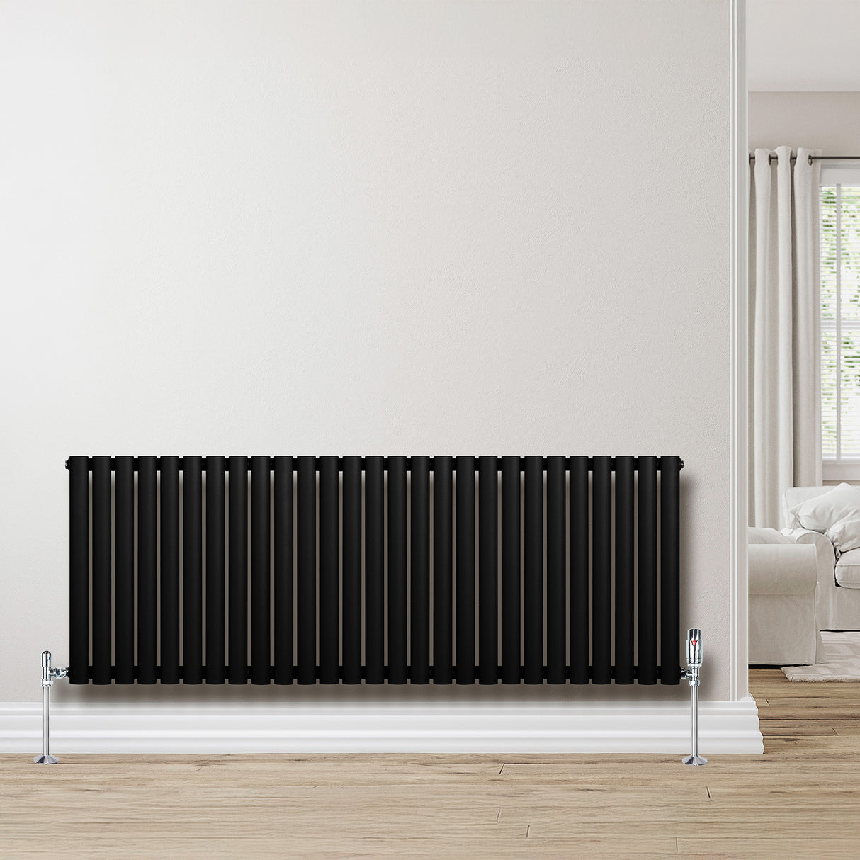 Ovale zwarte design radiator met één kolom, 600 mm x 1620 mm, geplaatst tegen een lichte muur in een moderne woonkamer