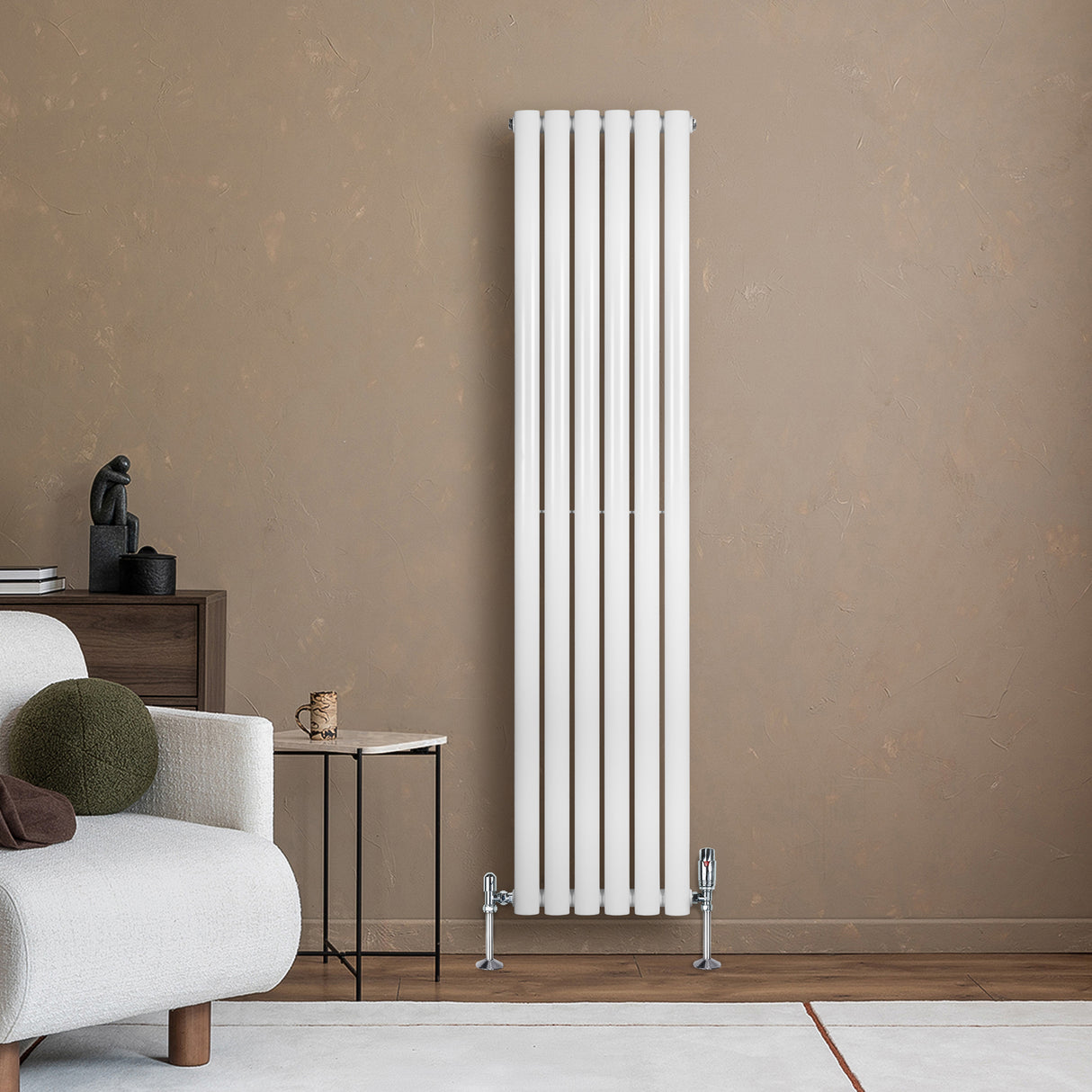 Ovale witte designradiator van 1600 mm x 360 mm met een haakse thermostaatkraan, geplaatst tegen een warme, neutrale muur