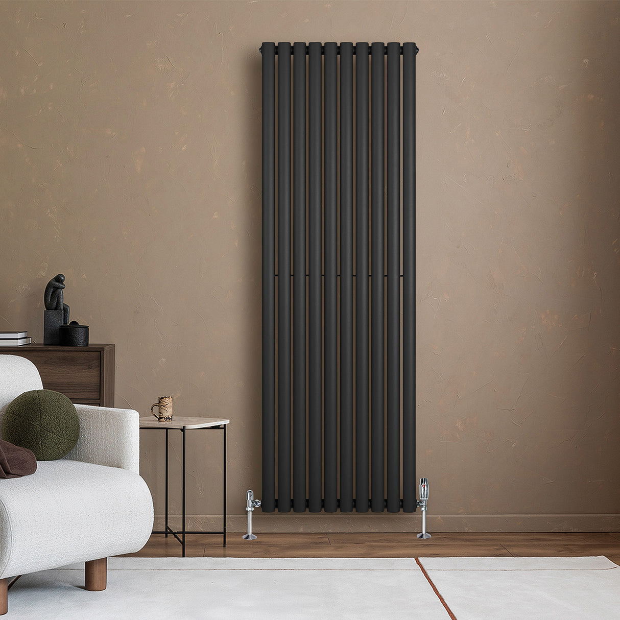 Ovale zwarte designradiator met één kolom, 1800 mm x 600 mm, geplaatst tegen een warme, neutrale muur in een moderne woonkamer