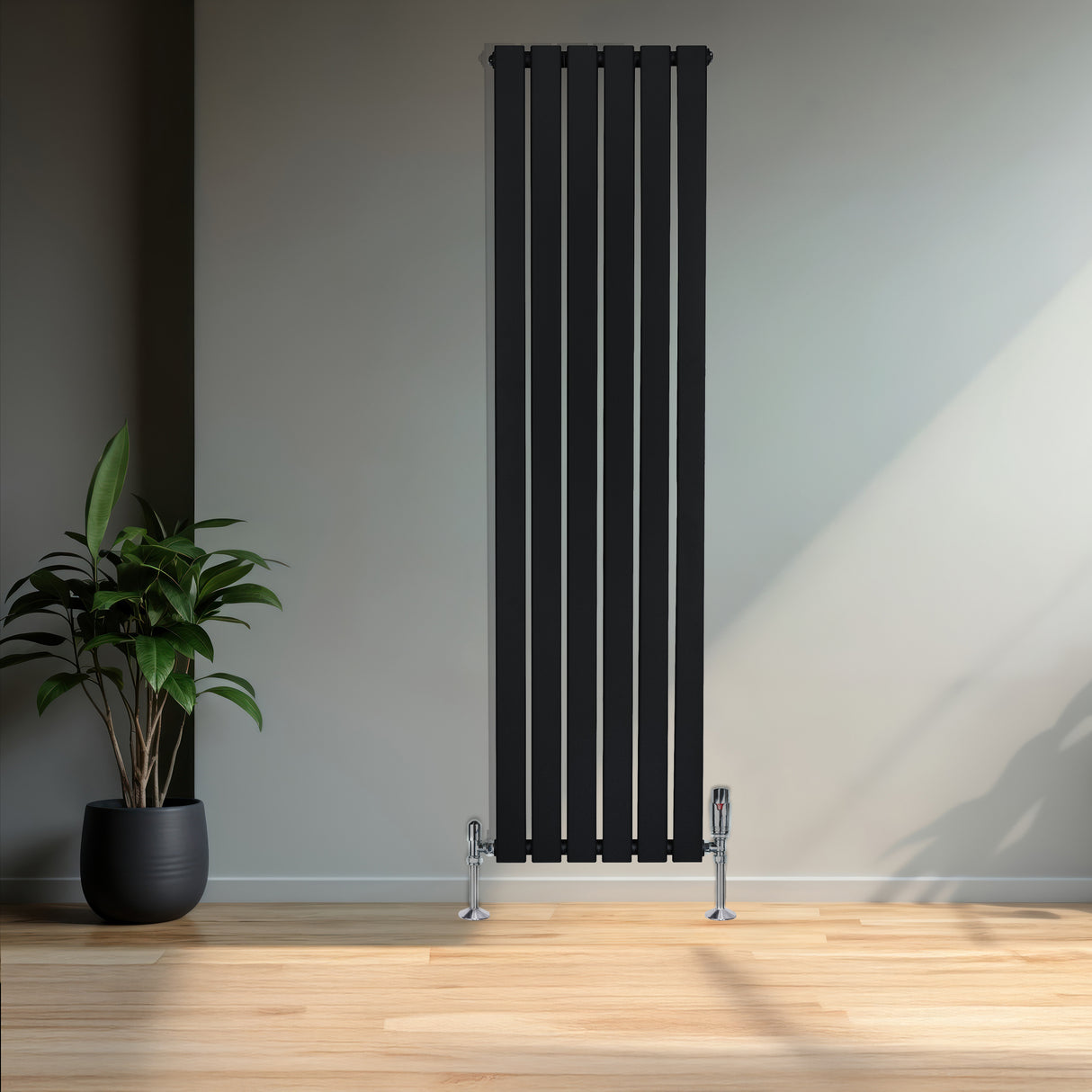 Zwart designradiator met vlakke panelen en een haakse thermostaatkraan, geplaatst tegen een lichte muur met een groene plant ernaast