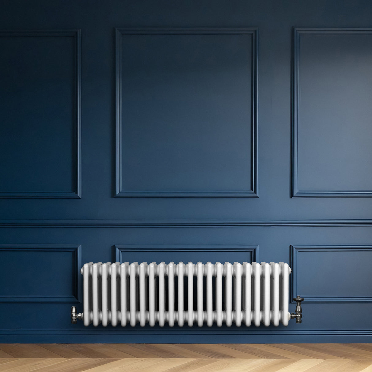 Traditionele witte 4-kolom radiator van 300 x 1010 mm, geplaatst tegen een diepblauwe wand met een stijlvolle houten vloer