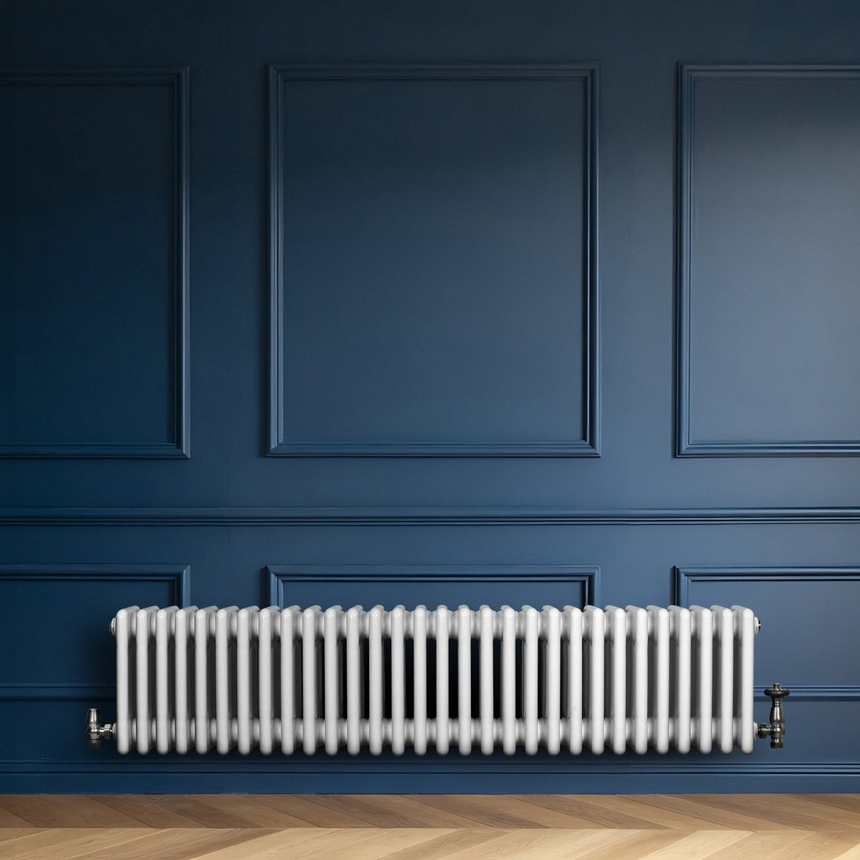 Traditionele witte 4-kolom radiator van 300 x 1370 mm tegen een diepblauwe wand, met een glanzende afwerking en ronde vormen