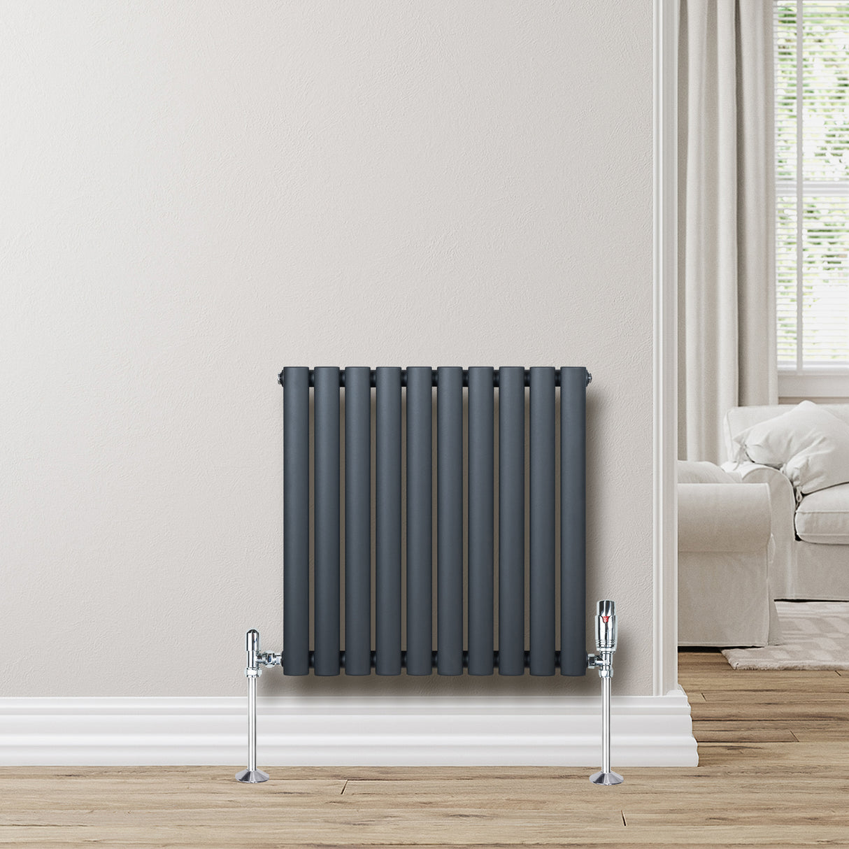 Ovale design radiator in antraciet grijs, 600 mm x 600 mm, met een moderne uitstraling en verticale kolommen, geplaatst tegen een lichte muur