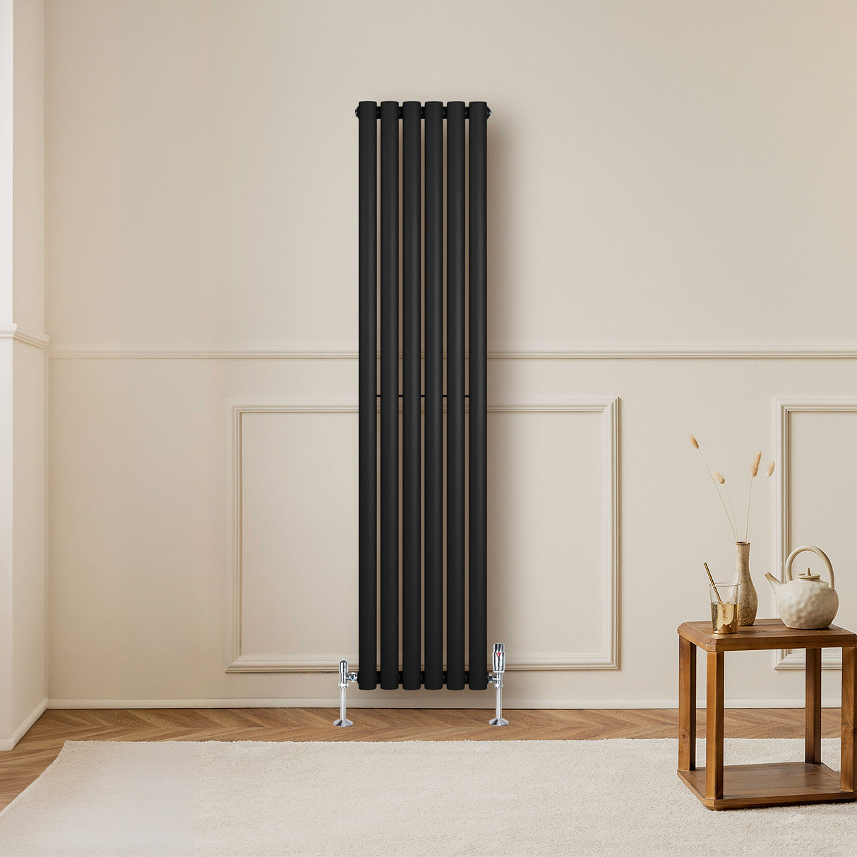 Ovale zwarte design radiator met één kolom, 1600 mm hoog en 360 mm breed, geplaatst tegen een lichte muur in een moderne ruimte