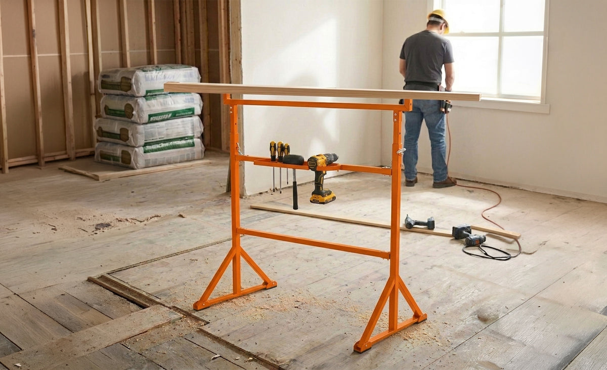 Een feloranje werktafel met een boormachine en houten plank, geplaatst in een lichte kamer met houten vloeren en bouwmaterialen op de achtergrond
