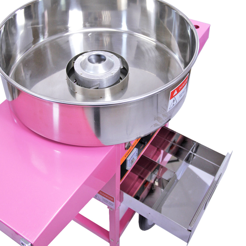 Roze suikerspinmachine met een glanzende roestvrijstalen kom en een lade voor het opbergen van benodigdheden en snoepjes