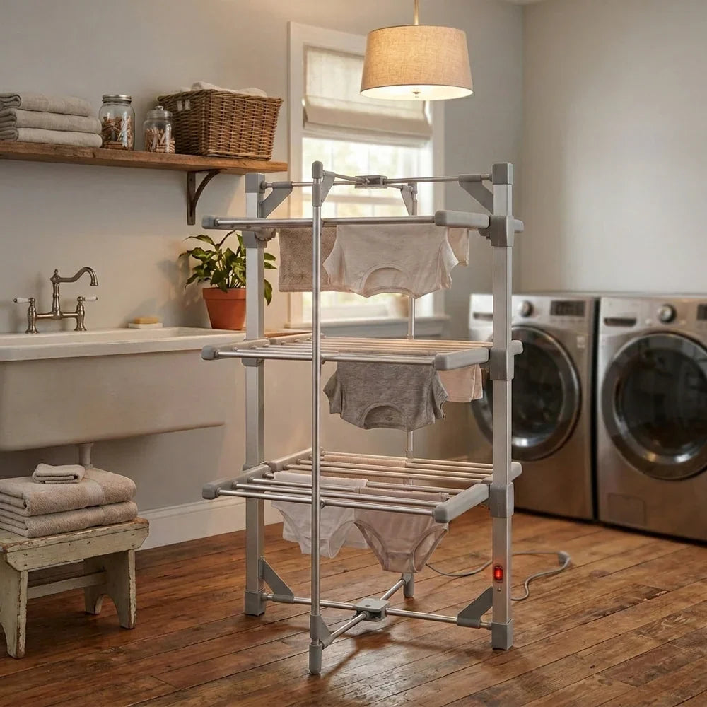 Een elektrisch droogrek met grijze was, geplaatst in een lichte, moderne wasruimte met houten vloer en wasmachine op de achtergrond