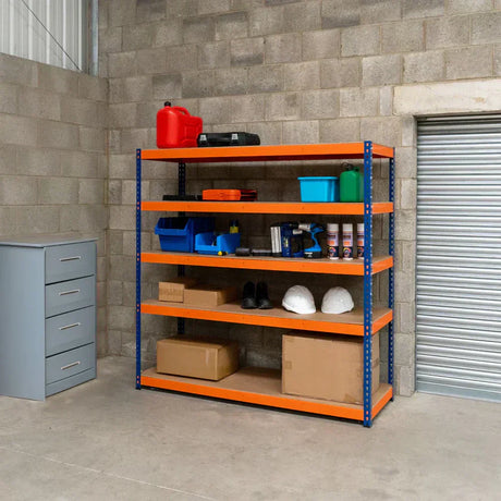 Een stevige metalen rek met oranje planken, gevuld met gereedschap, dozen, en veiligheidshelmen in een grijze opslagruimte