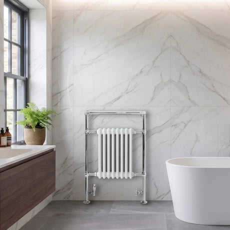 Stijlvolle handdoekradiator in chroom met witte, verticale buizen, geplaatst tegen een marmeren wand in een moderne badkamer