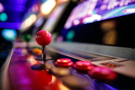 Kleurrijke retro arcadekast met een glanzende roze joystick en knoppen, perfect voor een mancave of gameroom sfeer