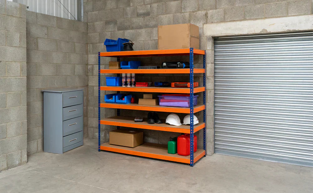 Kleurige stellingkast met oranje planken, gevuld met gereedschap, dozen en opslagcontainers in een garage met betonnen muren