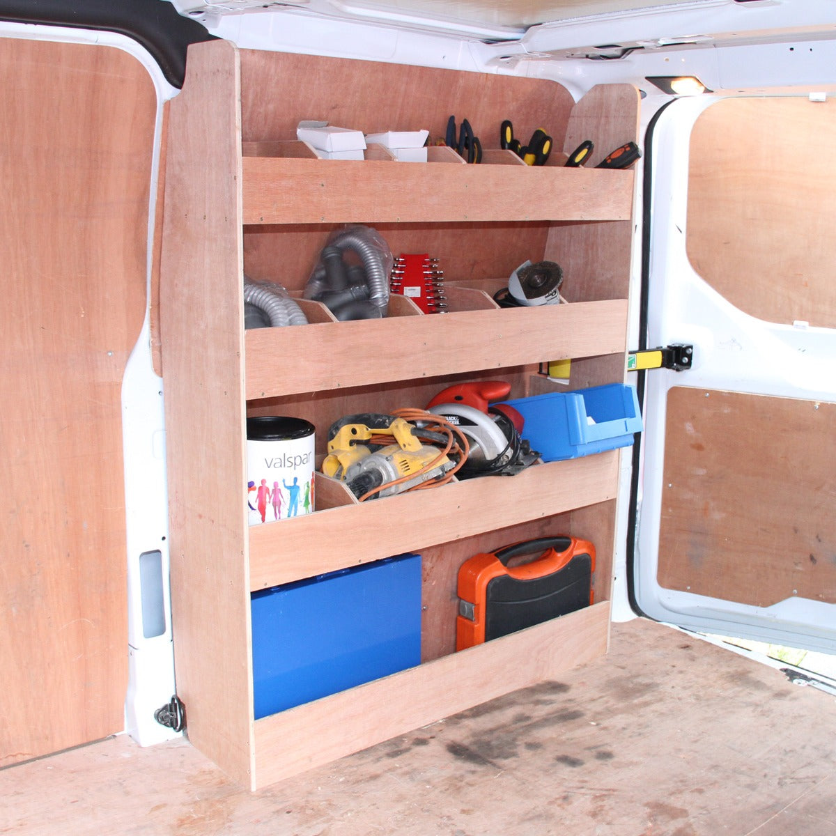Zwarte bestelwagenbekleding met een houten rek, gevuld met gereedschap en opbergdozen, in een Ford Transit Custom interieur