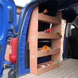 Zwarte bestelwagenbekleding met een houten rek, drie planken gevuld met gereedschap en materialen, geplaatst in een Citroën Berlingo