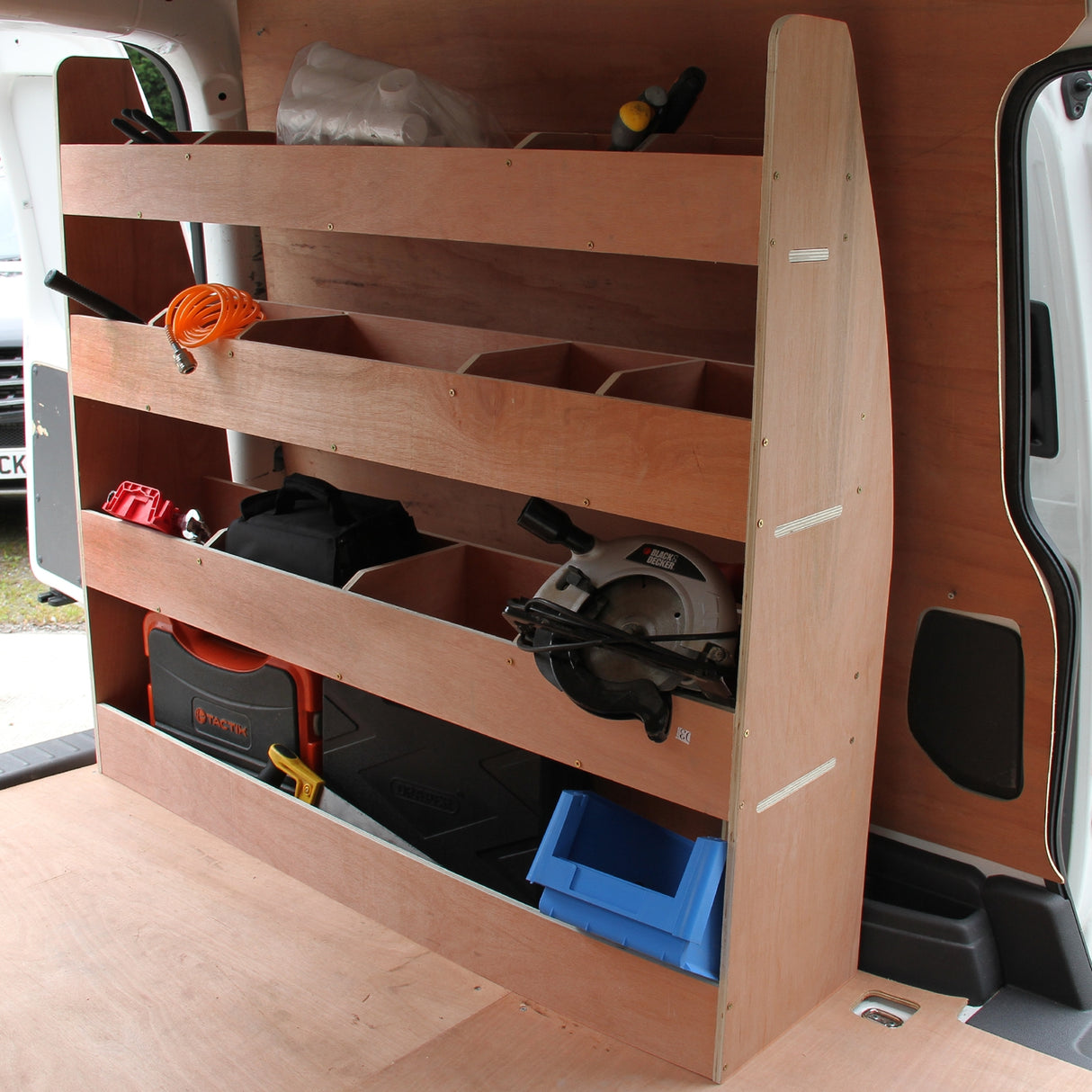 Antraciet bestelwagenbekleding met houten rek, voorzien van opbergvakken voor gereedschap en materialen in een VW Caddy