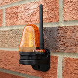 Heldere oranje waarschuwingslamp met antenne, gemonteerd op een bakstenen muur, biedt zichtbaarheid en veiligheid voor poortopeners