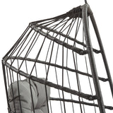 Zwart rotan hangstoel met een open structuur, afgewerkt met stevige touwen en een comfortabele grijze kussen voor extra steun