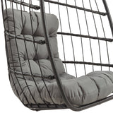 Zwarte rotan hangstoel met een comfortabele, grijze kussen en een opengewerkt, modern ontwerp voor een stijlvolle uitstraling