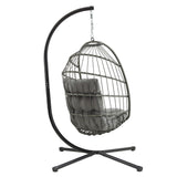 Grijze rotan hangstoel met een comfortabele kussen, hangend aan een zwart metalen frame met een stevige basis en elegante vorm