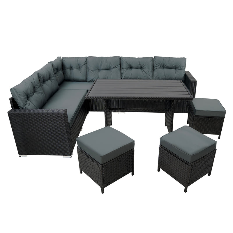 Luxe hoekbank van zwart wicker met comfortabele grijze kussens en een bijpassende salontafel en poefjes voor buitengebruik