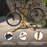 Zwarte mountainbike op een oranje fietsmontagestandaard met een magnetisch gereedschapsbakje en 360° draaibare frameklem