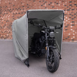 Zwarte motorfiets met een moderne uitstraling, beschermd door een grijze tent, geplaatst tegen een bakstenen muur