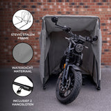Zwart motorfiets onder een grijze, waterdichte hoes met stevig stalen frame, geplaatst tegen een bakstenen muur, inclusief 2 hangsloten