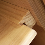 Natuurlijke houten plank met een gladde afwerking en een hoekige rand, perfect voor het ondersteunen van uittrekbare rieten manden