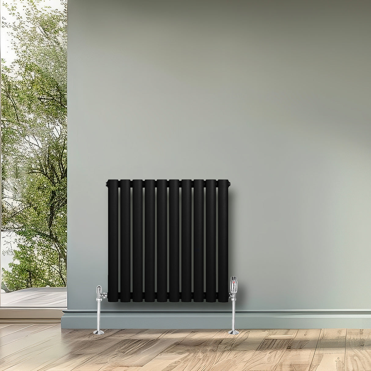 Zwarte ovale design radiator met één kolom, 600 mm x 600 mm, inclusief haakse thermostaatkraan, geplaatst tegen een lichte muur