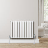 Ovale witte design radiator met één kolom, 600 mm x 780 mm, inclusief haakse thermostaatkraan, geplaatst tegen een lichte muur