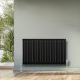 Ovale zwarte designradiator met één kolom, 600 mm x 1020 mm, inclusief haakse thermostaatkraan, tegen een lichte muur