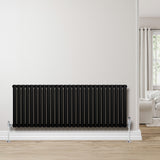Ovale zwarte design radiator met één kolom, 600 mm x 1620 mm, geplaatst tegen een lichte muur in een moderne woonkamer