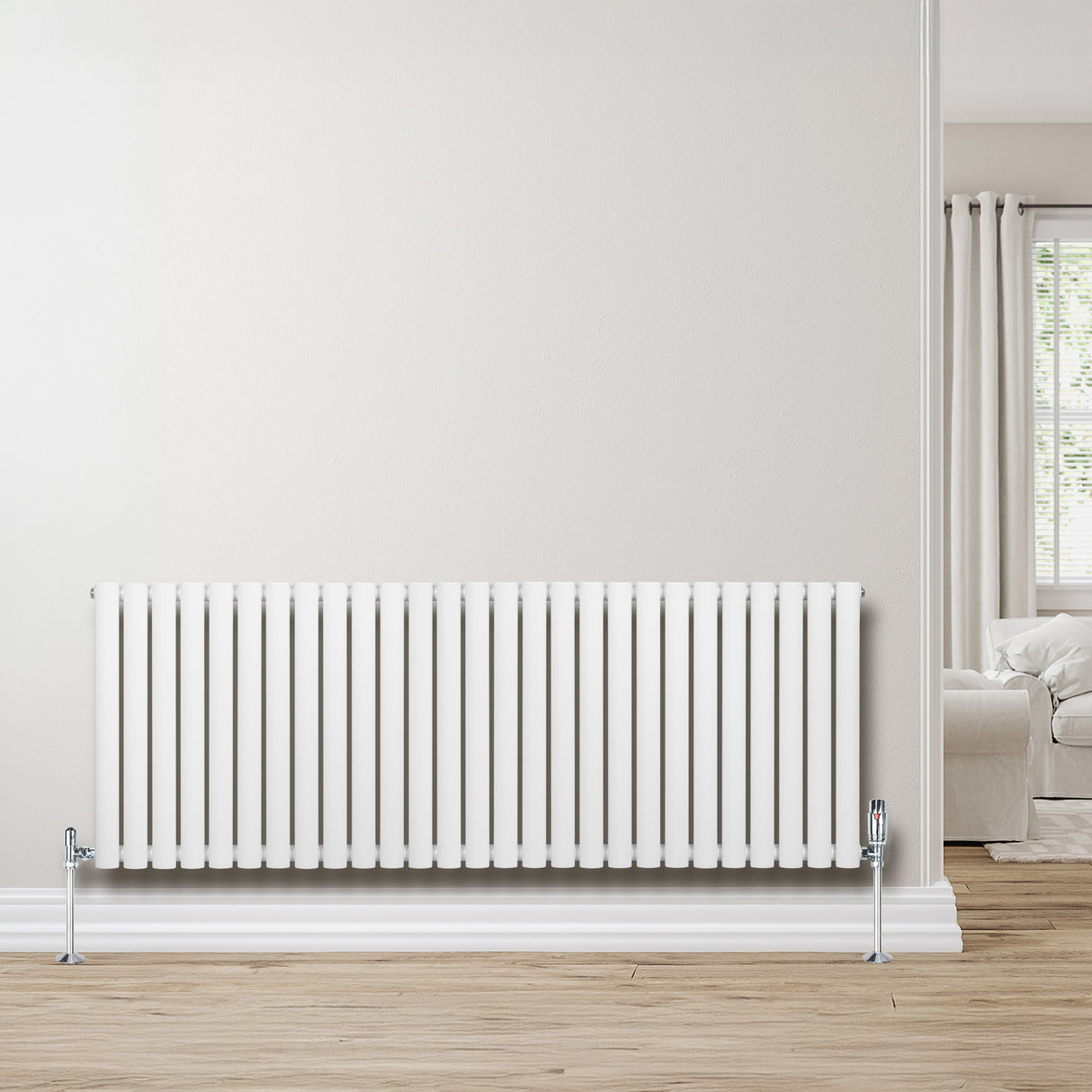 Ovale witte design radiator van 600 mm x 1620 mm met een haakse thermostaatkraan, geplaatst tegen een lichte muur in een moderne woonkamer