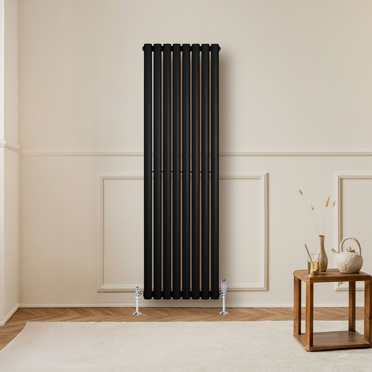Ovale zwarte designradiator van 1 kolom, 1600 mm x 480 mm, met haakse thermostaatkraan, geplaatst in een moderne interieursetting