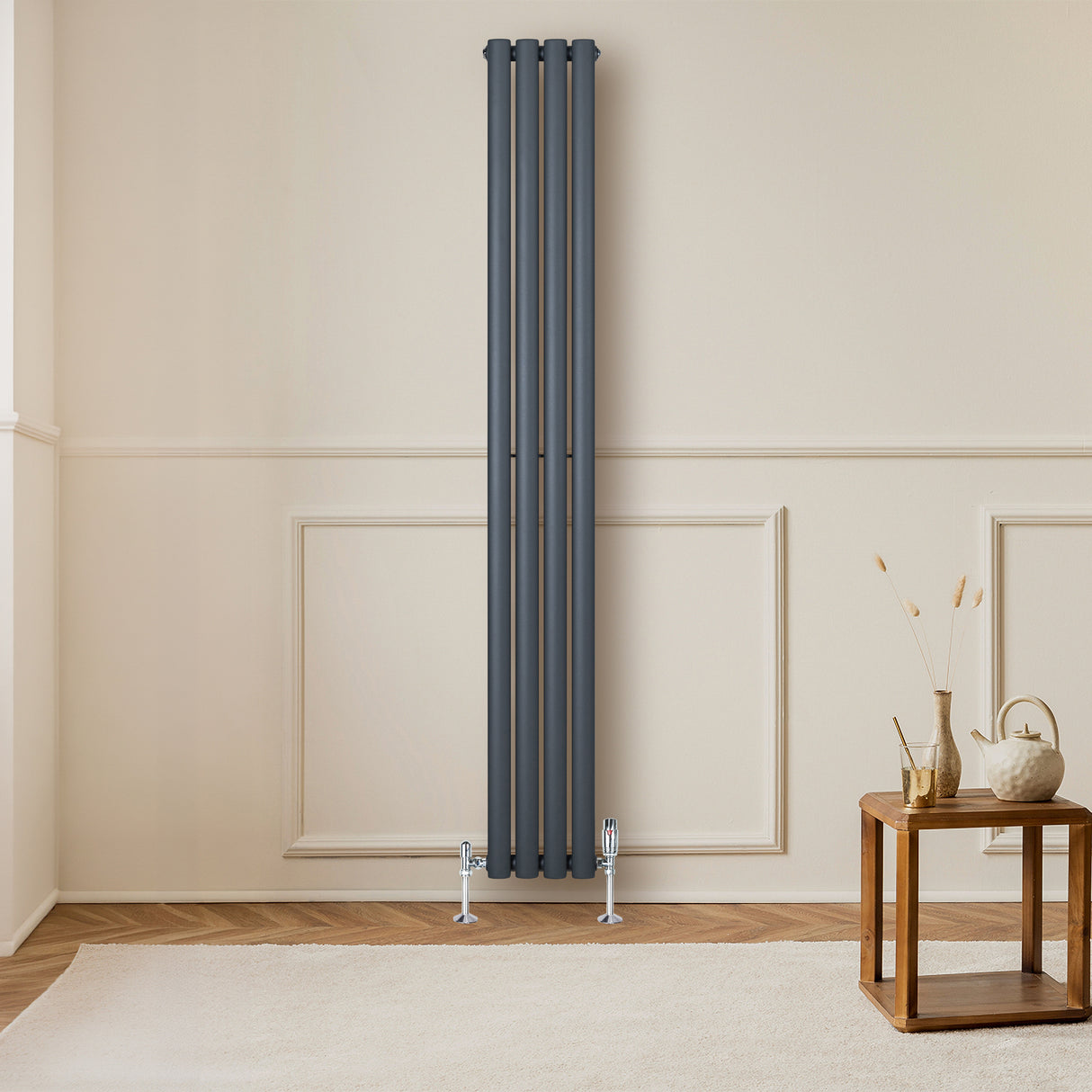 Ovale design radiator in antraciet grijs, 1800 mm x 240 mm, met haakse thermostaatkraan, geplaatst tegen een lichte muur