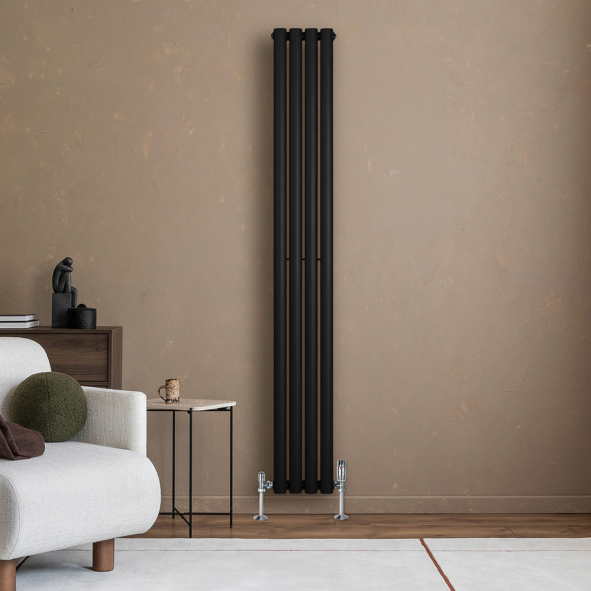 Ovale zwarte designradiator van 1800 mm x 240 mm met haakse thermostaatkraan, geplaatst tegen een beige muur in een moderne woonkamer
