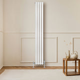 Ovale witte designradiator van 1800 mm x 240 mm met haakse thermostaatkraan, geplaatst tegen een lichte muur in een moderne ruimte