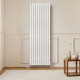 Ovale witte designradiator van 1800 mm x 600 mm met haakse thermostaatkraan, geplaatst tegen een lichte muur in een moderne ruimte
