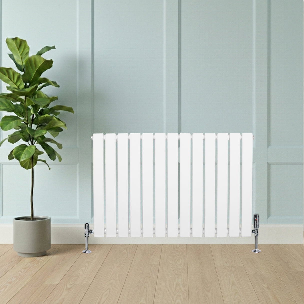Witte designradiator met vlakke panelen en haakse thermostaatkraan, geplaatst tegen een lichte wand, naast een groene plant