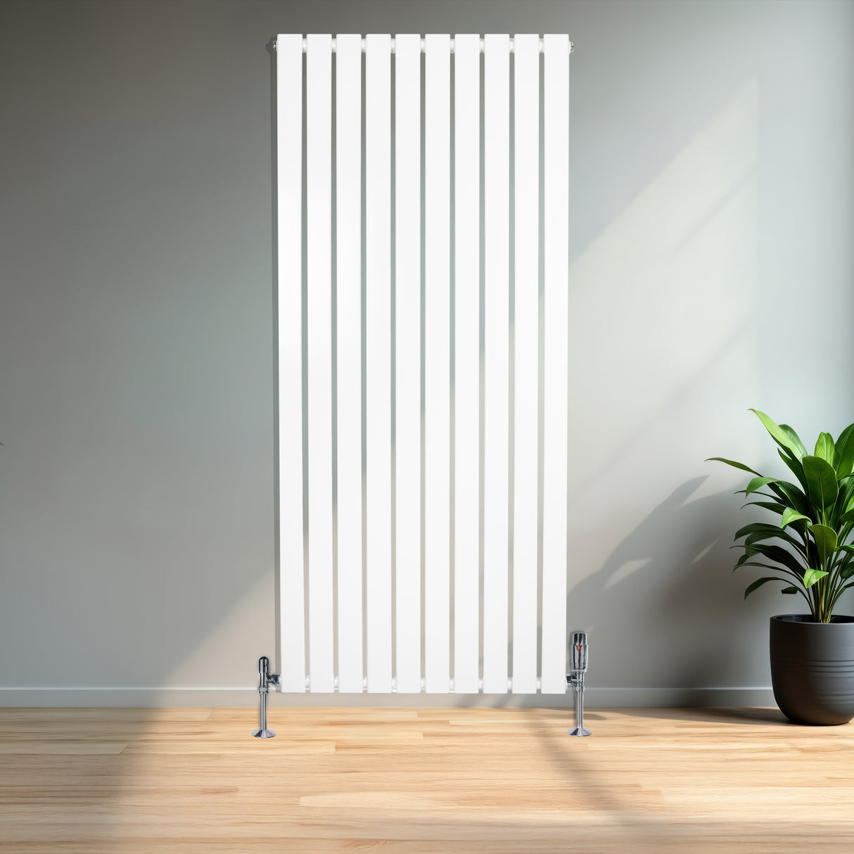 Witte design radiator met vlakke panelen en haakse thermostaatkraan, geplaatst tegen een muur in een moderne ruimte met houten vloer en planten