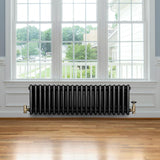Traditionele zwarte 4-kolom radiator van 300 x 1010 mm met haakse thermostaatkraan, geplaatst onder een groot raam op houten vloer