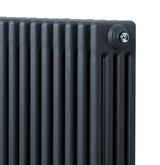 Traditionele antraciet grijze 4-kolom radiator met een strakke afwerking en haakse thermostaatkraan voor optimale verwarming