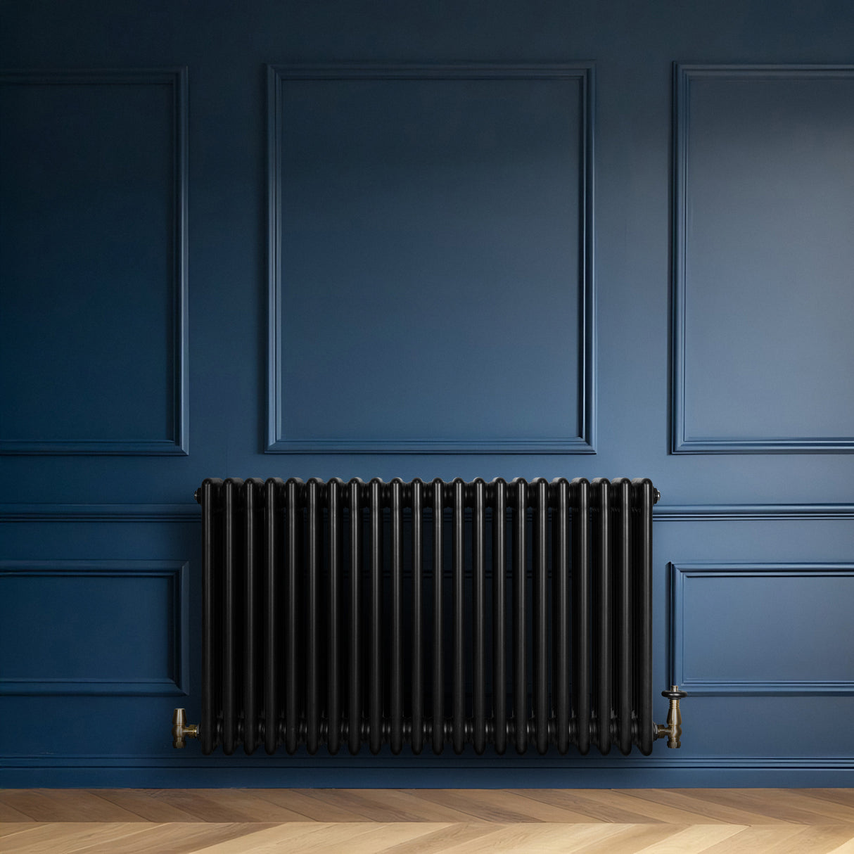 Traditionele zwarte 4-kolom radiator van 600 x 1010 mm met glanzende afwerking en haakse thermostaatkraan tegen een blauwe muur