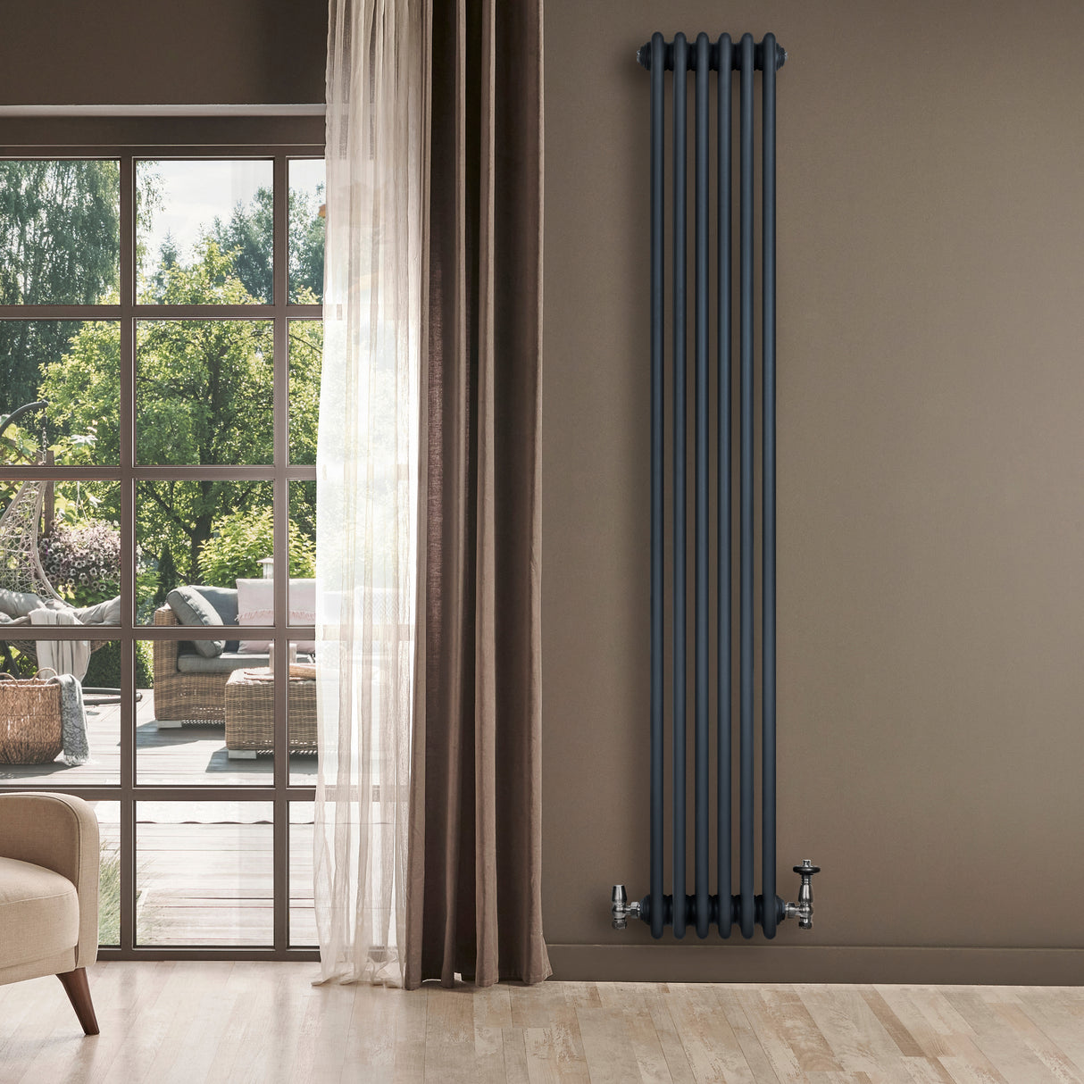 Traditionele antraciet grijze 4-kolom radiator van 1800 x 290 mm met haakse thermostaatkraan, geplaatst tegen een muur met raam