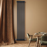 Traditionele antraciet grijze 4-kolom radiator van 1800 x 380 mm met haakse thermostaatkraan, geplaatst tegen een warme muur